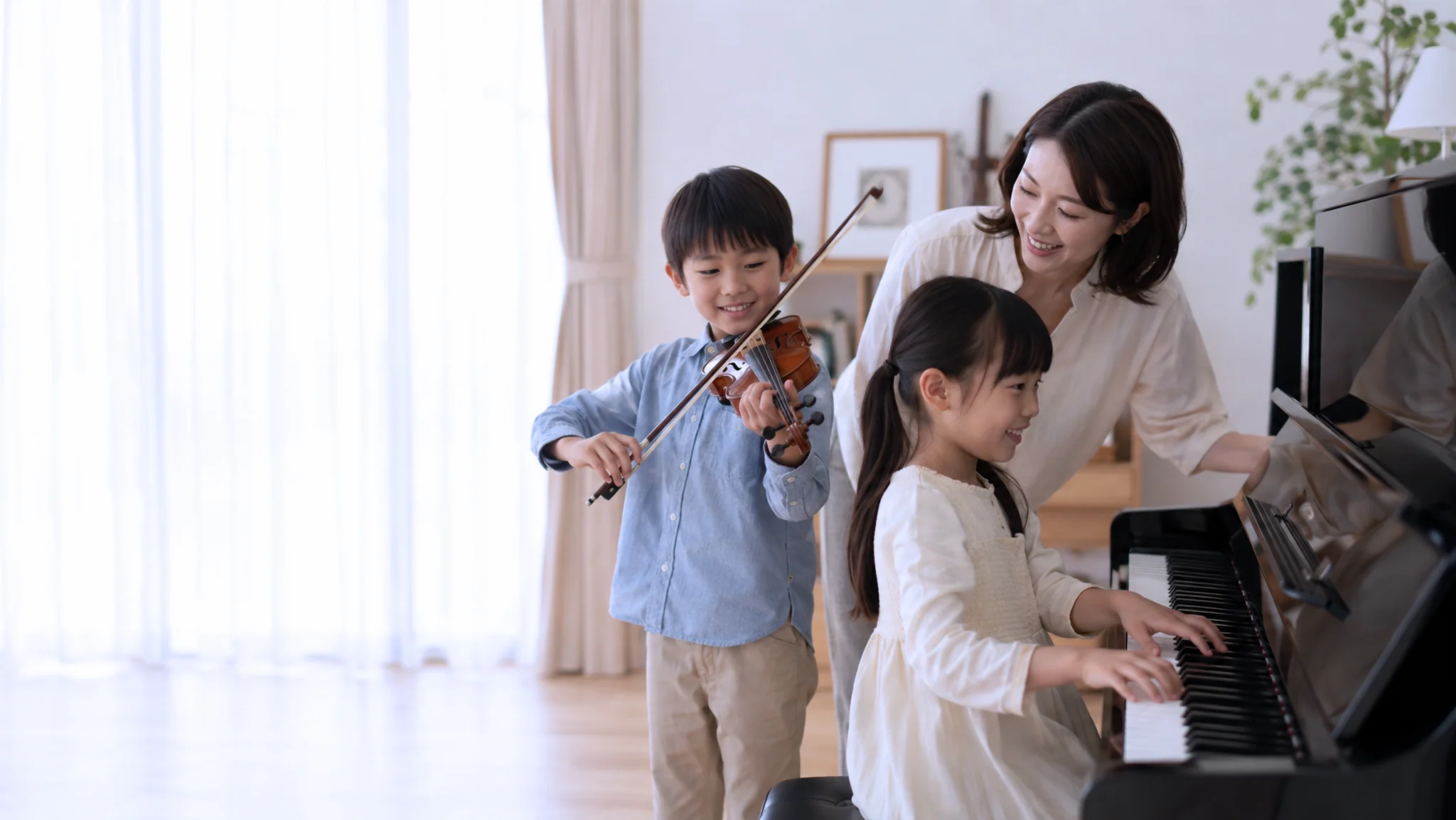 A boy playing violin and a girl at the piano with their teacher during a music lesson at home